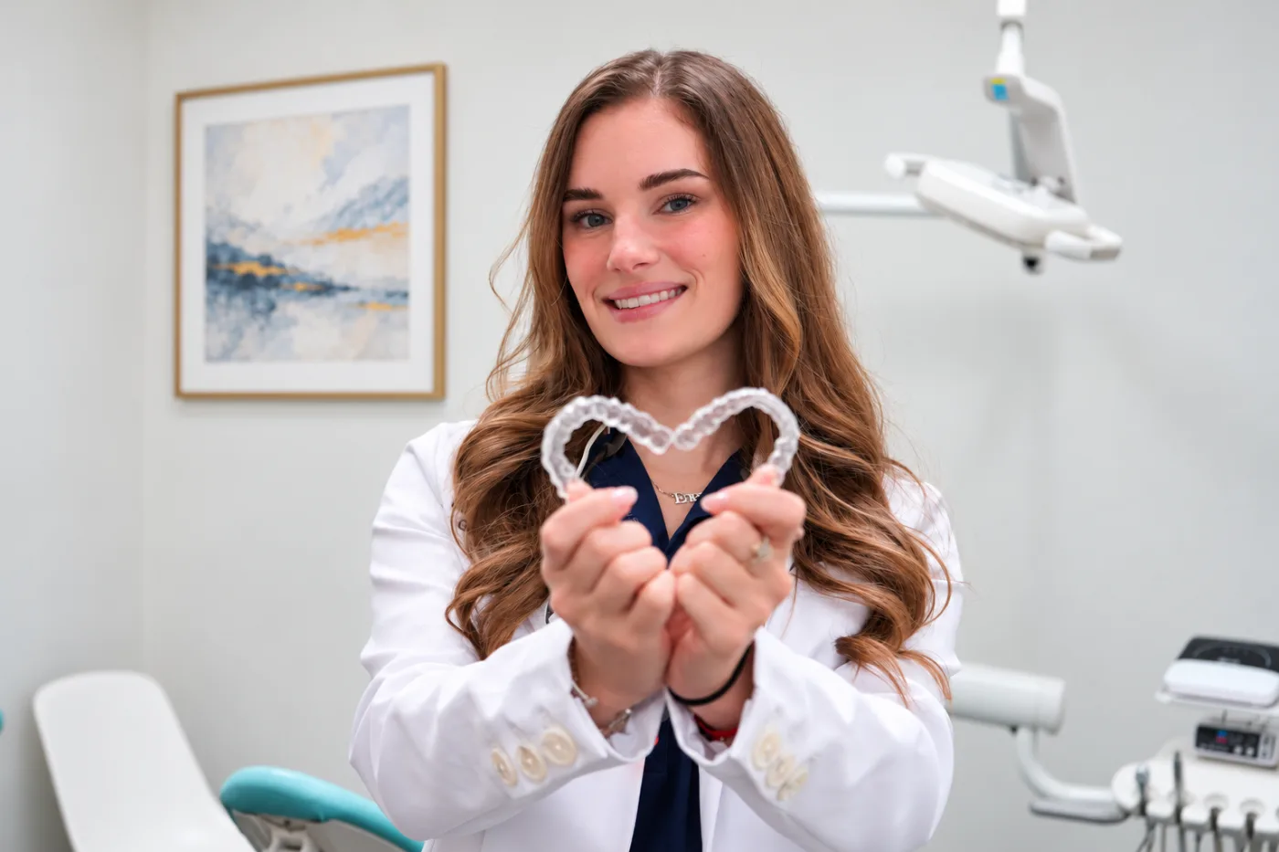 Dr. Elena Nemirovskii, DDS, McKinney TX dentist, holding clear aligners